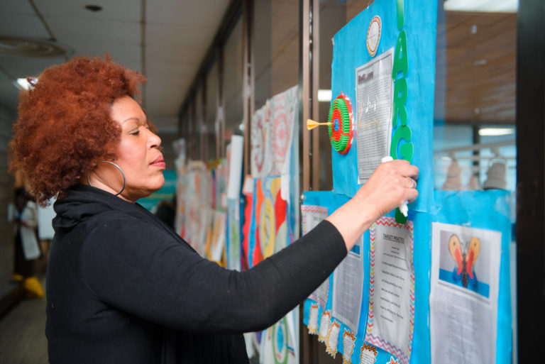 Bernadette Scott, Unconference planning committee member, adjusts pop-up display